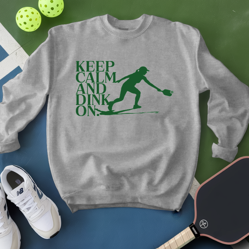 Gray sweatshirt with green text and pickleball-related items on a green and blue background