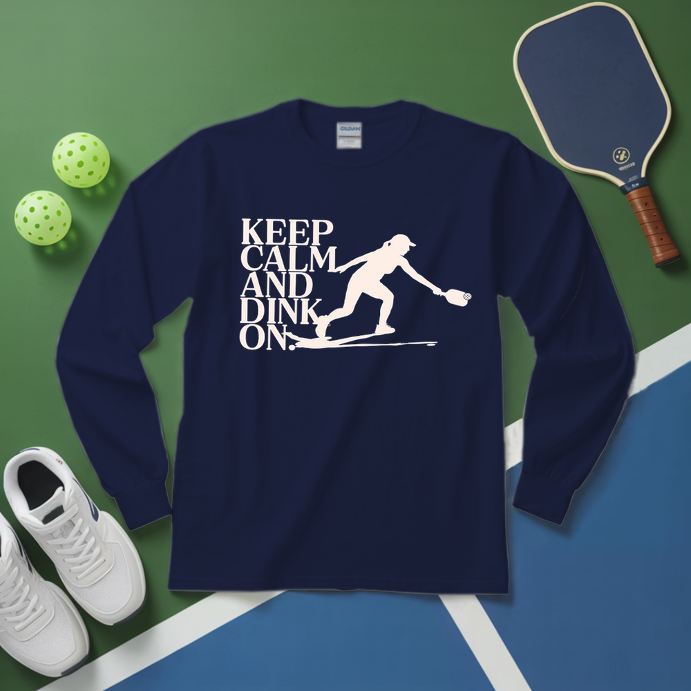 Navy blue sweatshirt with 'Keep Calm and Dink On' graphic on a green and blue surface with pickleball equipment.