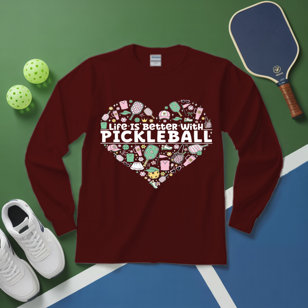 Maroon long-sleeve shirt with pickleball-themed design on a green and blue surface with pickleballs and a paddle.