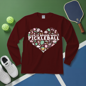 Maroon long-sleeve shirt with pickleball-themed design on a green and blue surface with pickleballs and a paddle.