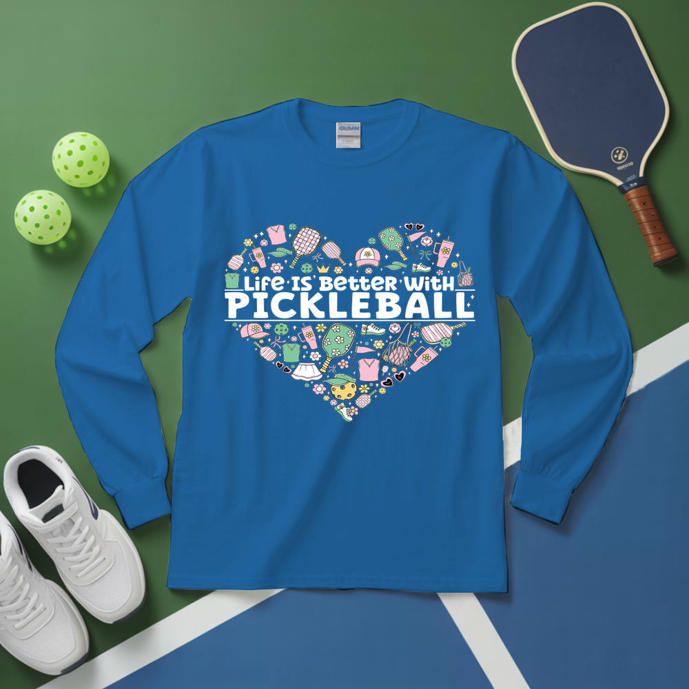 Blue long-sleeve shirt with pickleball-themed design on a green and blue surface with pickleballs and a paddle.
