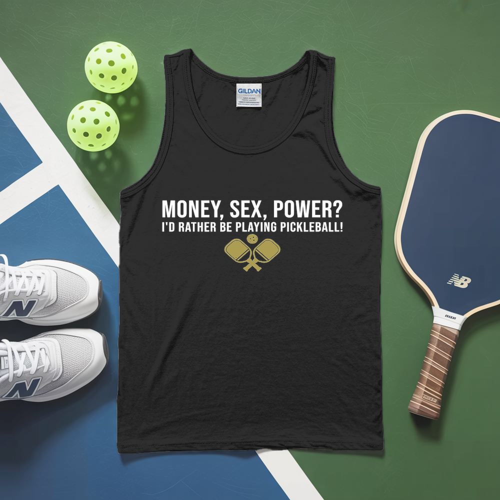 Black tank top with humorous pickleball text, pickleballs, paddle, and shoes on a green and blue surface.