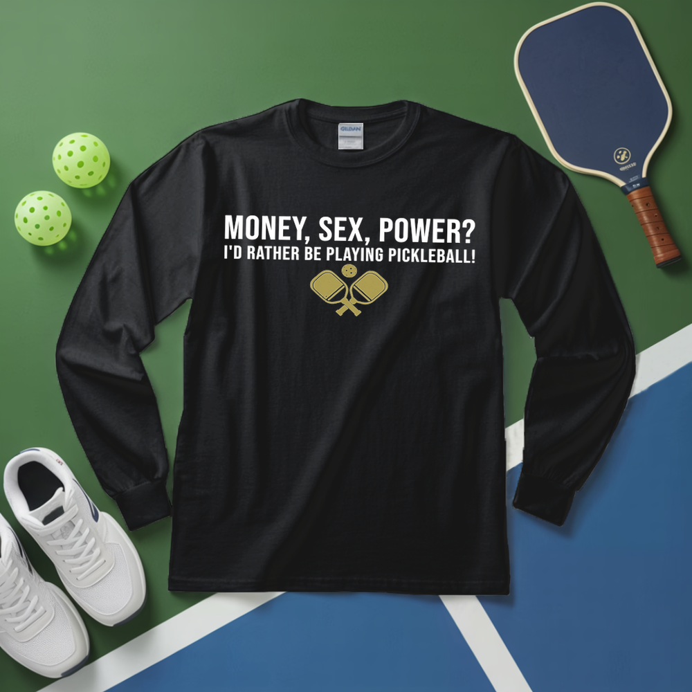 Black long-sleeve shirt with pickleball-themed text on a green and blue surface with pickleball equipment.