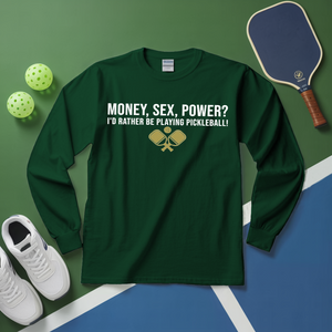 Green long-sleeve shirt with pickleball-themed text on a green and blue surface with pickleball equipment.
