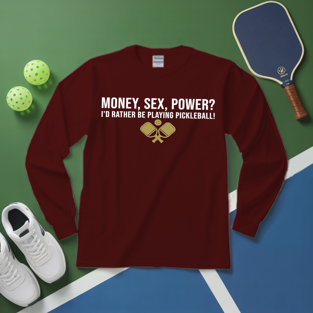 Maroon long-sleeve shirt with pickleball-themed text and graphics on a green and blue surface with pickleball equipment.