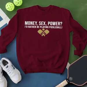 Maroon sweatshirt with pickleball-themed text and graphics on a green and blue background.