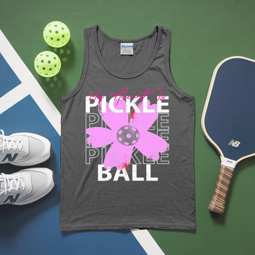 Gray tank top with pickleball design on a green and blue surface with pickleballs and a paddle.