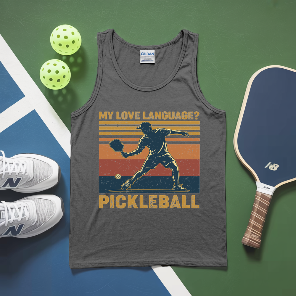 Gray tank top with pickleball design, pickleballs, and paddle on a green and blue surface