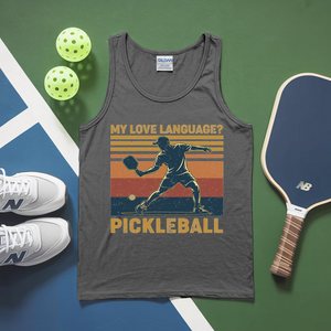 Gray tank top with pickleball design, pickleballs, and paddle on a green and blue surface