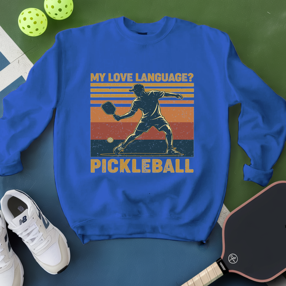Blue sweatshirt with pickleball design and text on a green and blue gradient background