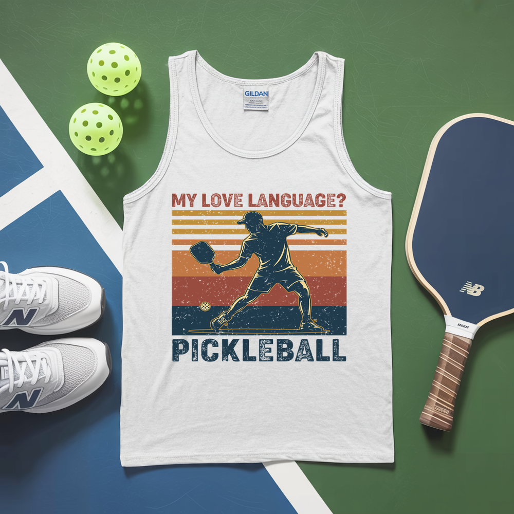 White tank top with pickleball design, sneakers, and paddle on a green and blue surface