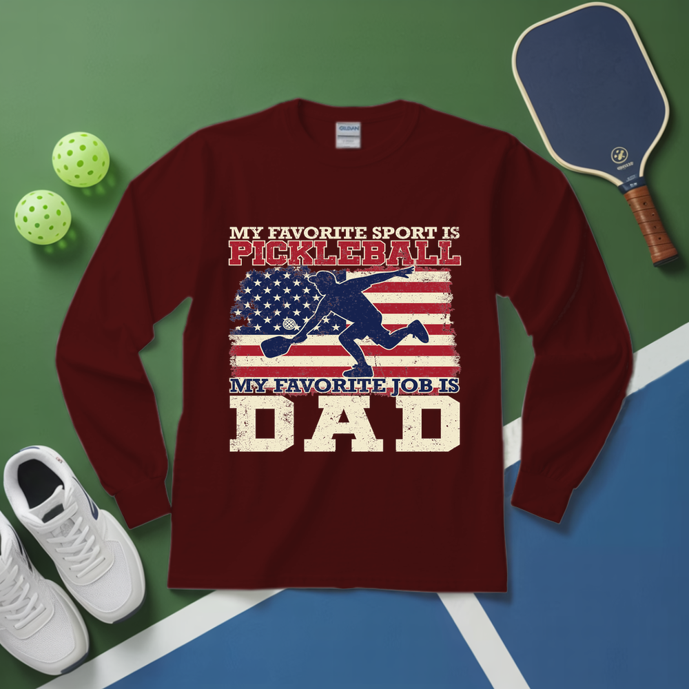 Maroon long-sleeve shirt with pickleball-themed design on a green and blue surface with pickleball equipment.