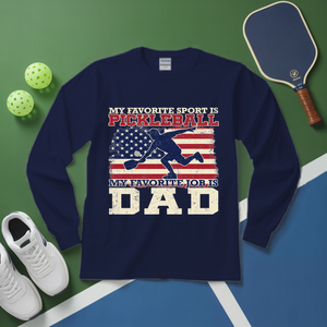 Navy blue sweatshirt with pickleball-themed design on a green and blue surface with pickleball equipment.