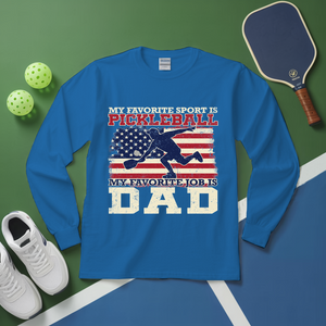 Blue long-sleeve shirt with pickleball-themed design on a green and blue background with pickleball equipment.