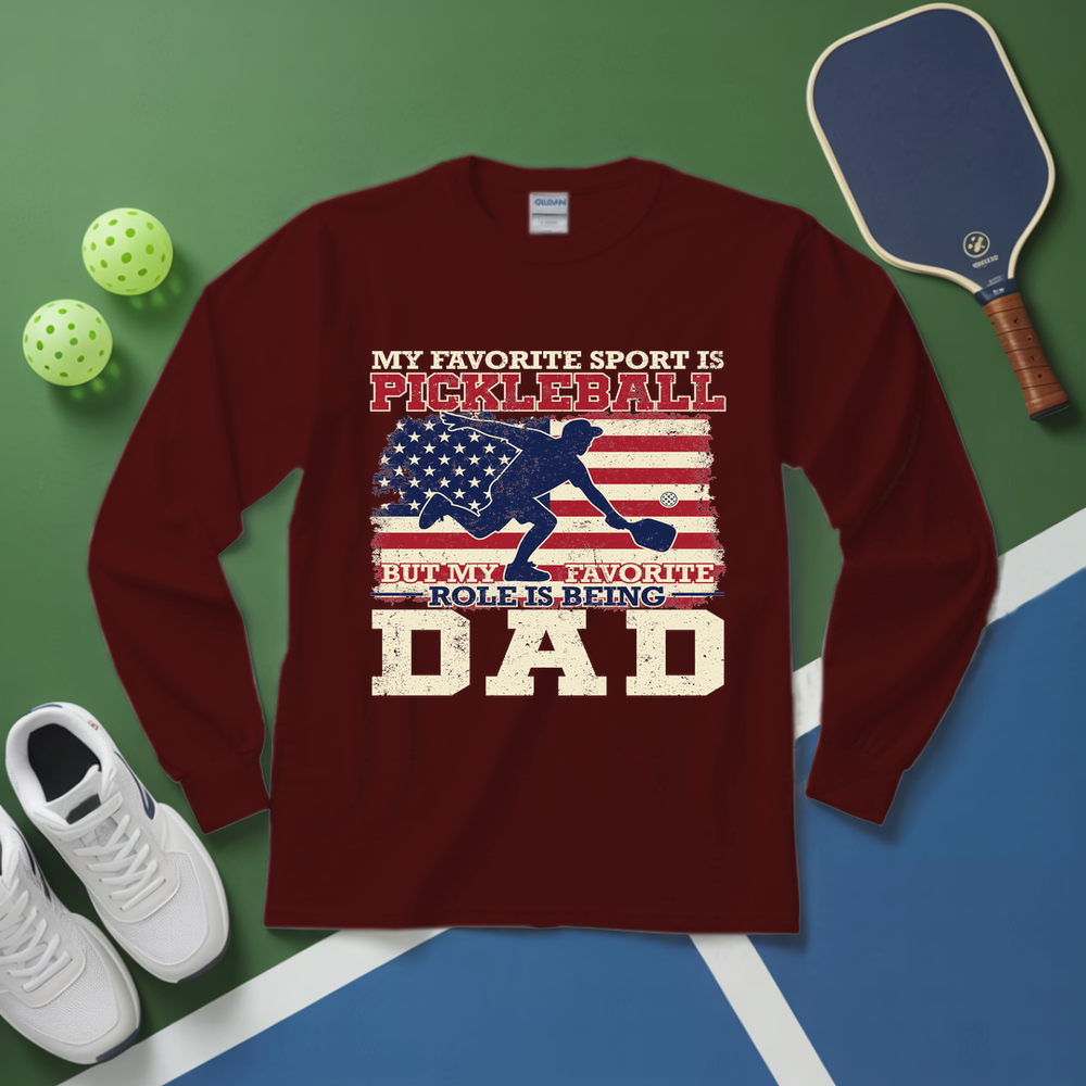 Maroon long-sleeve shirt with pickleball design and text on a green and blue surface with pickleball equipment.