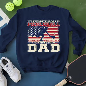 Navy blue sweatshirt with pickleball-themed design on a green and blue background