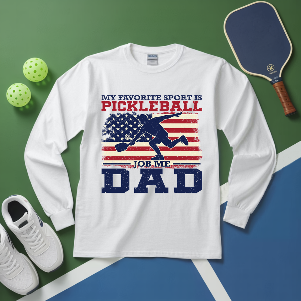 White long-sleeve shirt with pickleball-themed design on a green and blue background with pickleball equipment.