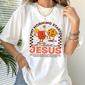 Person wearing a white t-shirt with pickleball and Jesus graphic design.