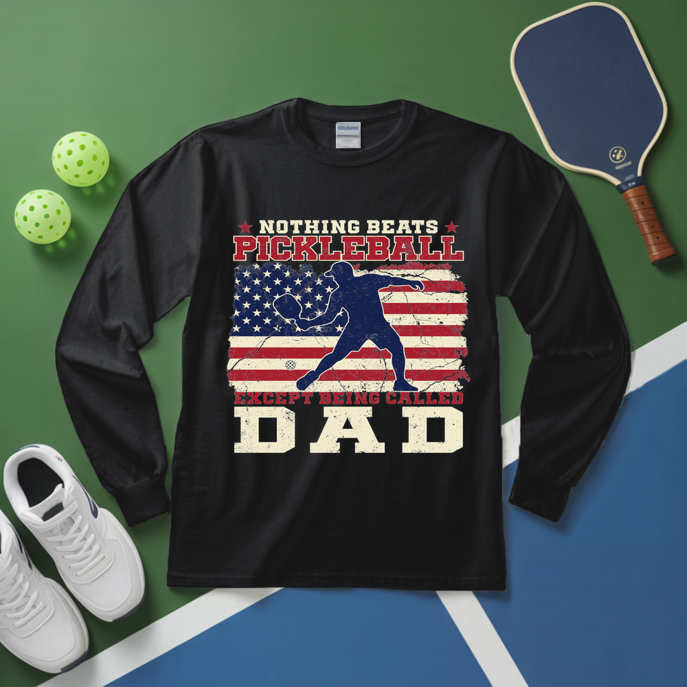 Black long-sleeve shirt with pickleball design on a green and blue surface with pickleball equipment.
