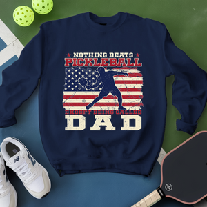 Navy blue sweatshirt with pickleball design and text on a green and blue background