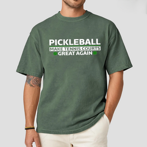 Person wearing a green t-shirt with pickleball-themed text on a plain background