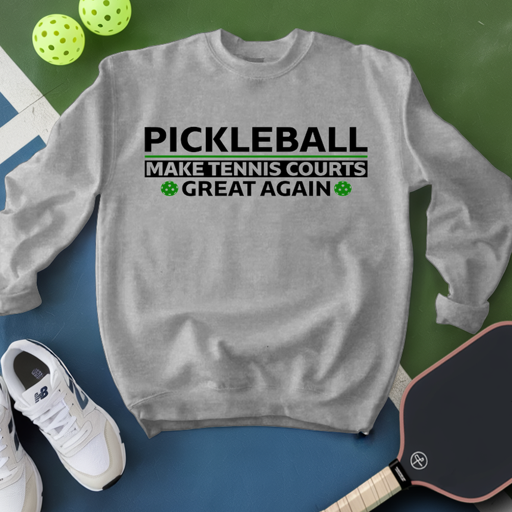 Gray sweatshirt with pickleball text, pickleball paddle, and balls on a green and blue background