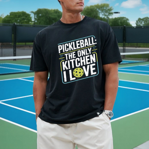 Person wearing a black t-shirt with pickleball-themed text on a tennis court