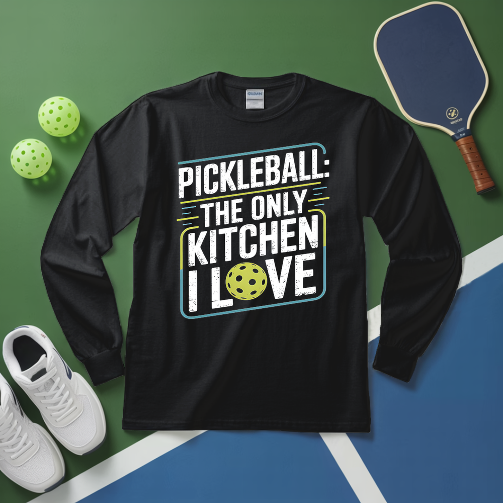 Black long-sleeve shirt with pickleball-themed text on a green and blue surface with pickleballs and a paddle.