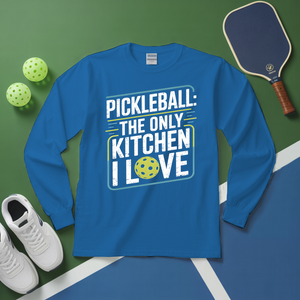 Blue long-sleeve shirt with pickleball-themed text on a green and blue surface with pickleball equipment.