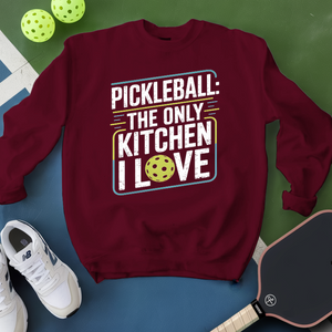 Maroon sweatshirt with pickleball-themed text on a green and blue background