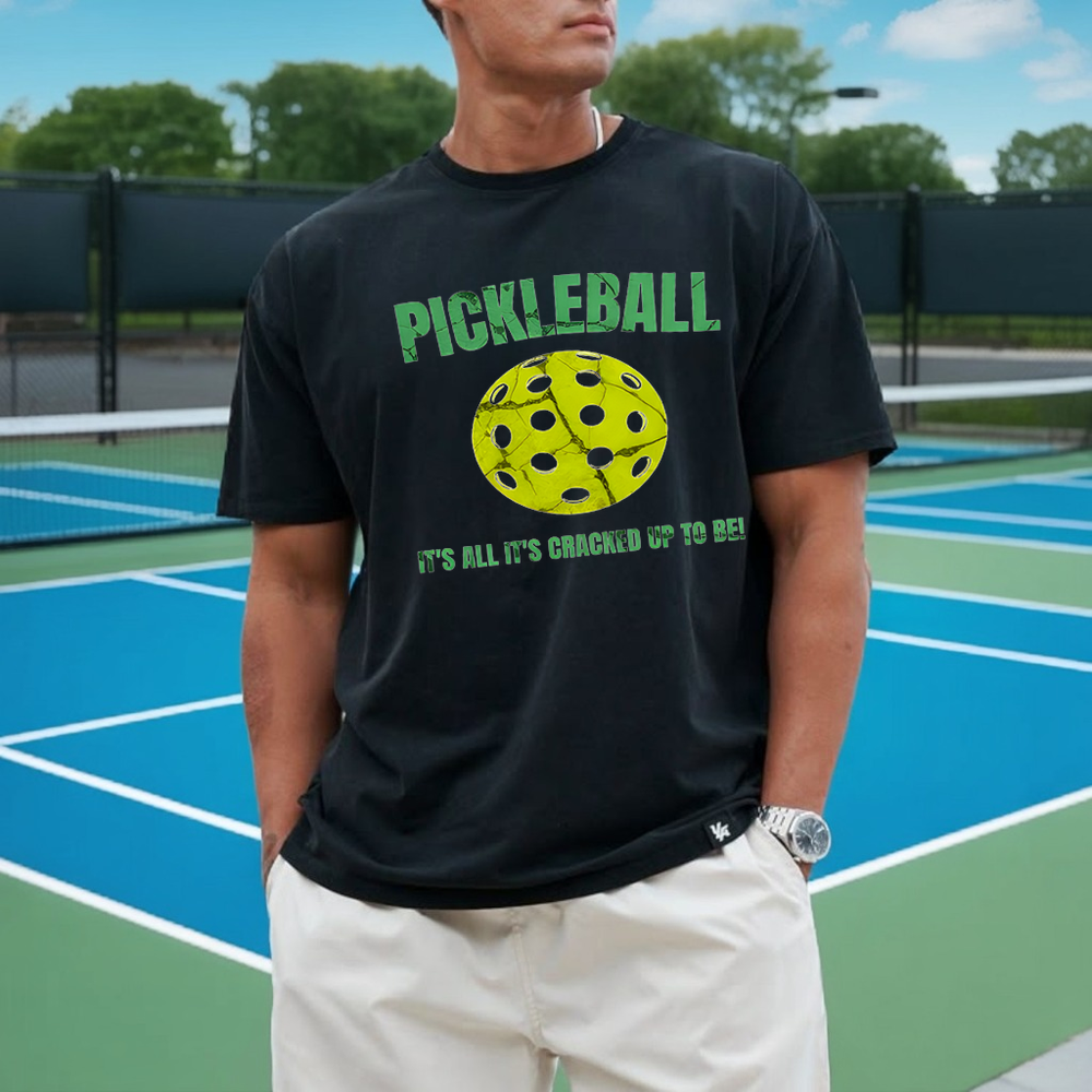Person wearing a black t-shirt with pickleball design on a tennis court