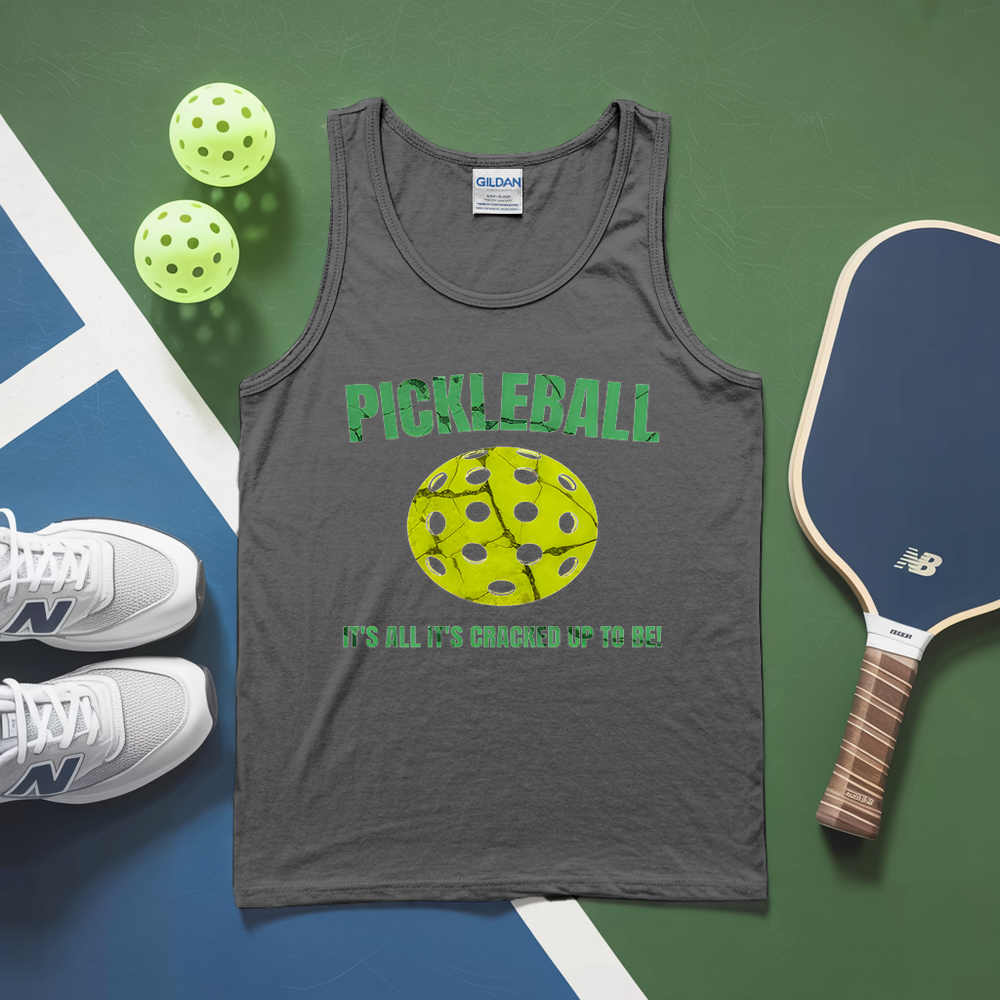 Gray tank top with pickleball design and text, pickleballs, and paddle on a green and blue surface.