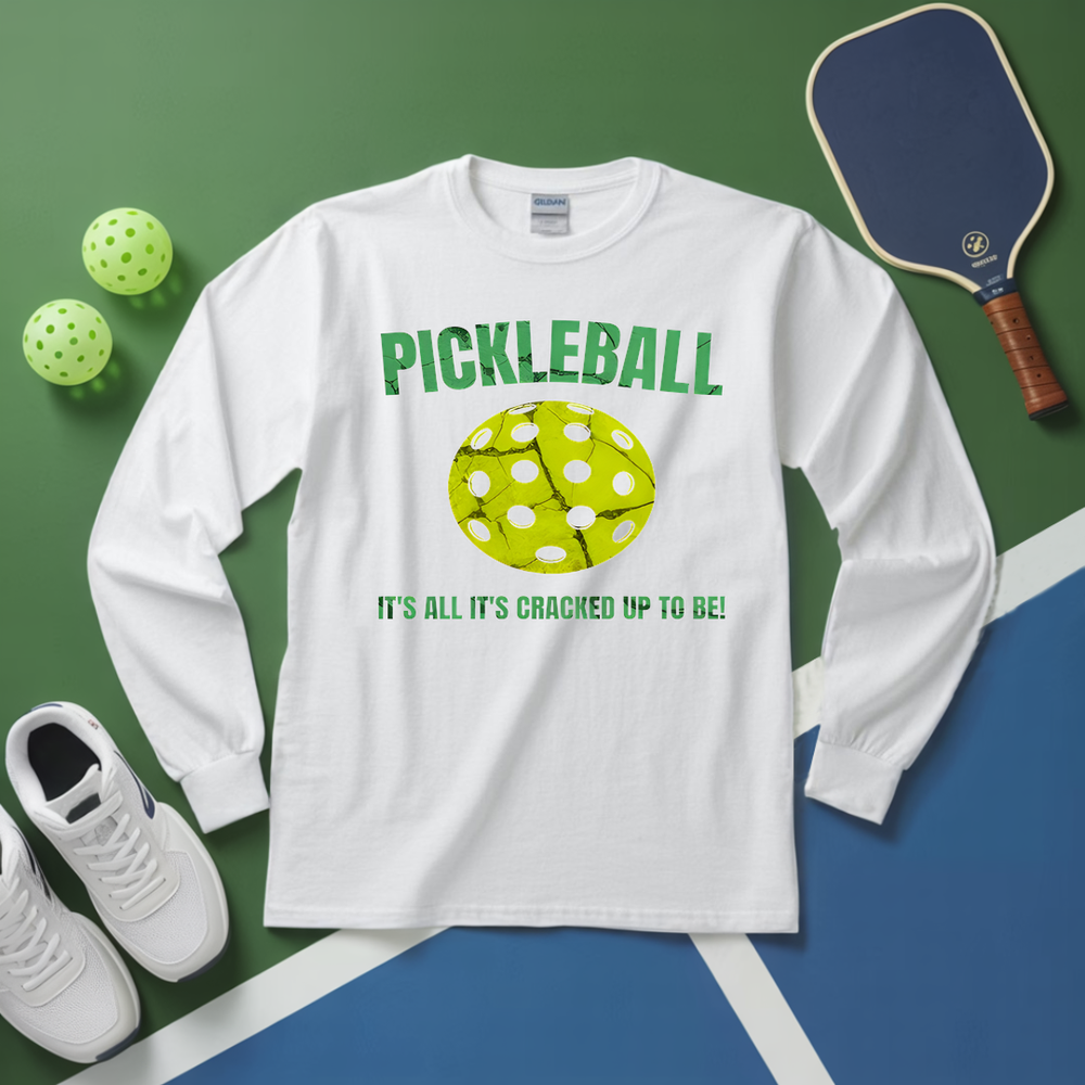 White long-sleeve shirt with pickleball design and text on a green and blue background with pickleballs and a paddle.
