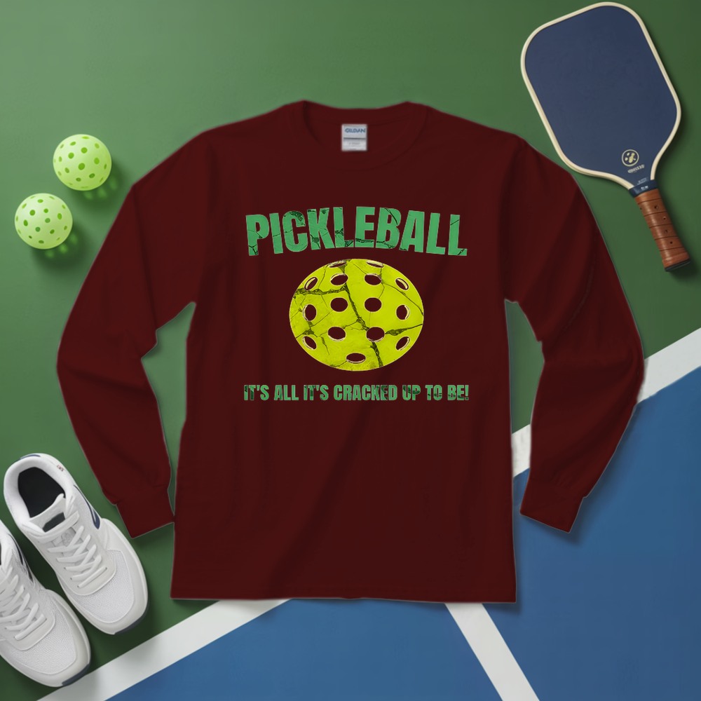 Maroon long-sleeve shirt with pickleball design on a green and blue surface with pickleballs and a paddle.