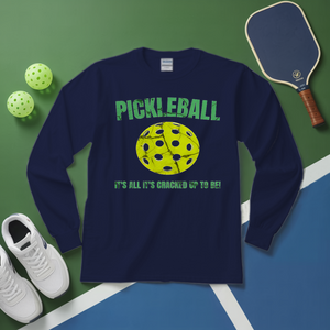 Navy blue long-sleeve shirt with pickleball graphic and text on a green and blue surface with pickleball equipment.