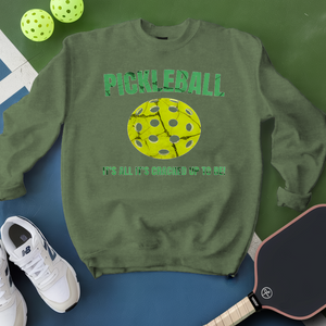 Green sweatshirt with pickleball design and text, surrounded by pickleballs and a paddle on a green and blue background.
