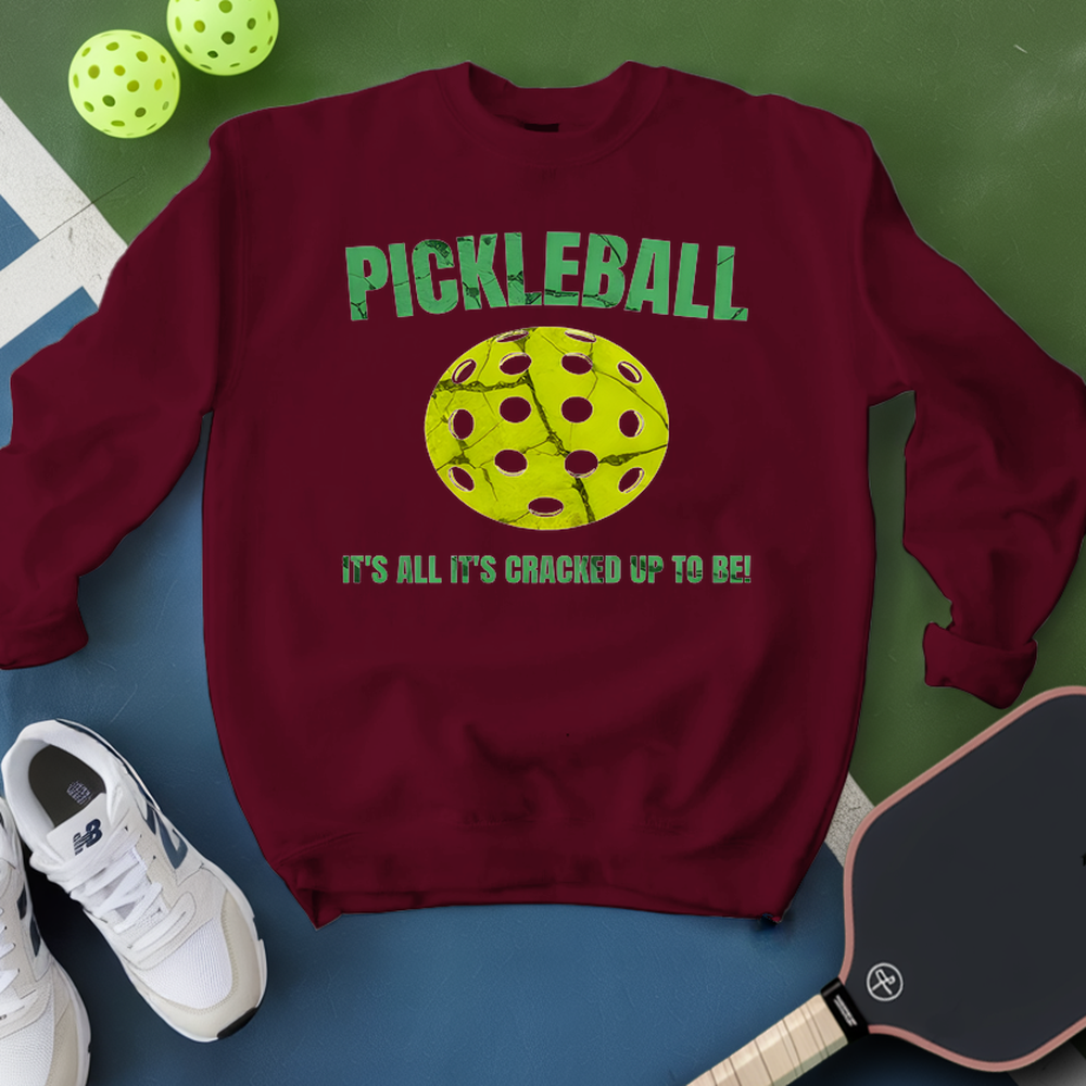Maroon sweatshirt with pickleball graphic and text on a green and blue background