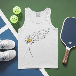 White tank top with dandelion design, pickleballs, and a paddle on a green and blue surface.