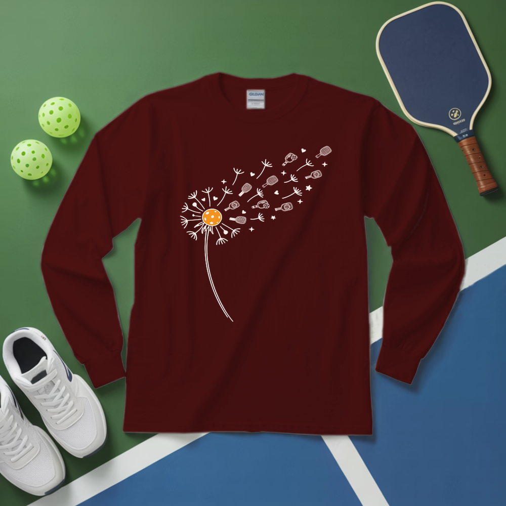 Maroon long-sleeve shirt with a dandelion design on a green and blue surface with sports equipment.