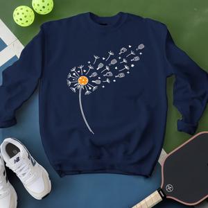 Navy blue sweatshirt with dandelion graphic on a green and blue surface with sports equipment.