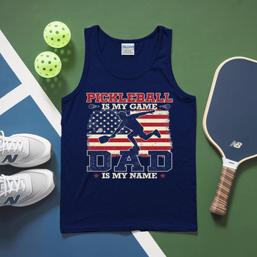 Navy tank top with pickleball design on a green and blue surface with pickleballs and a paddle.