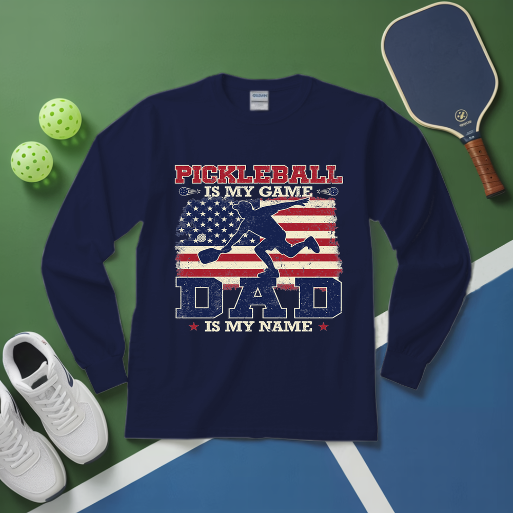 Navy blue sweatshirt with pickleball design on a green and blue surface with pickleball equipment.