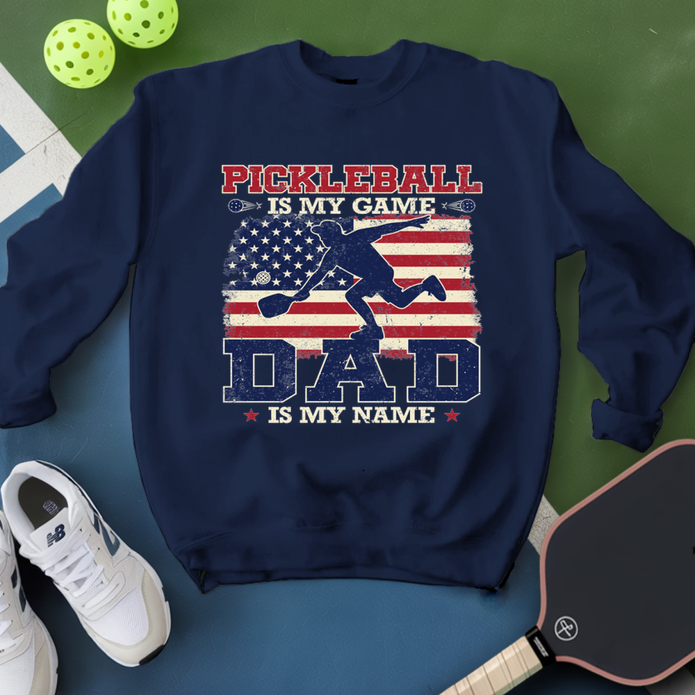 Navy blue sweatshirt with pickleball design and text on a green and blue background