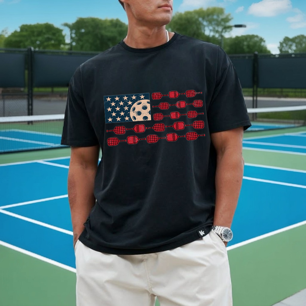 Person wearing a black t-shirt with a graphic design on a tennis court
