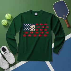 Green long-sleeve shirt with pickleball-themed design on a green and blue surface with pickleballs and a paddle.