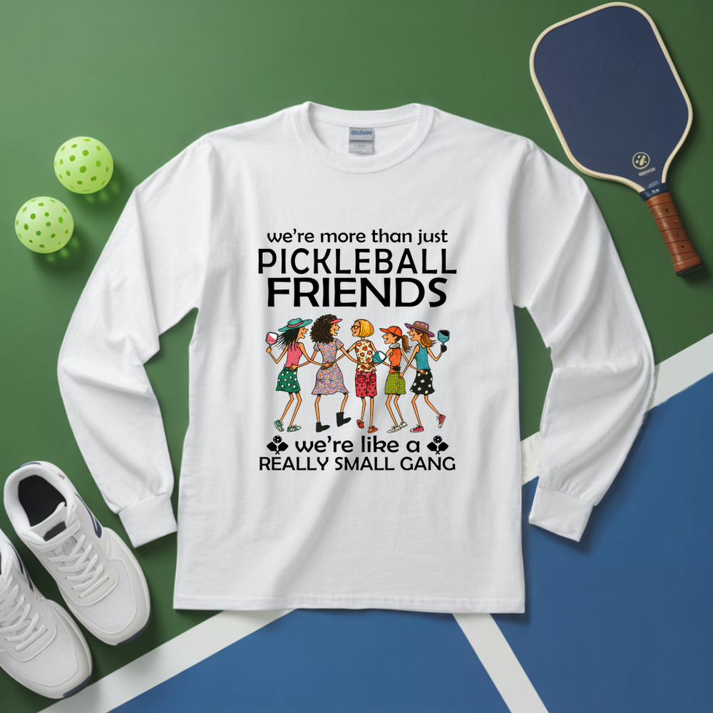 White long-sleeve shirt with pickleball-themed design on a green and blue background with pickleball equipment.