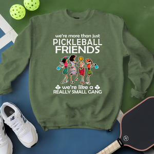 Green sweatshirt with pickleball-themed design on a blue surface with pickleballs and a paddle.