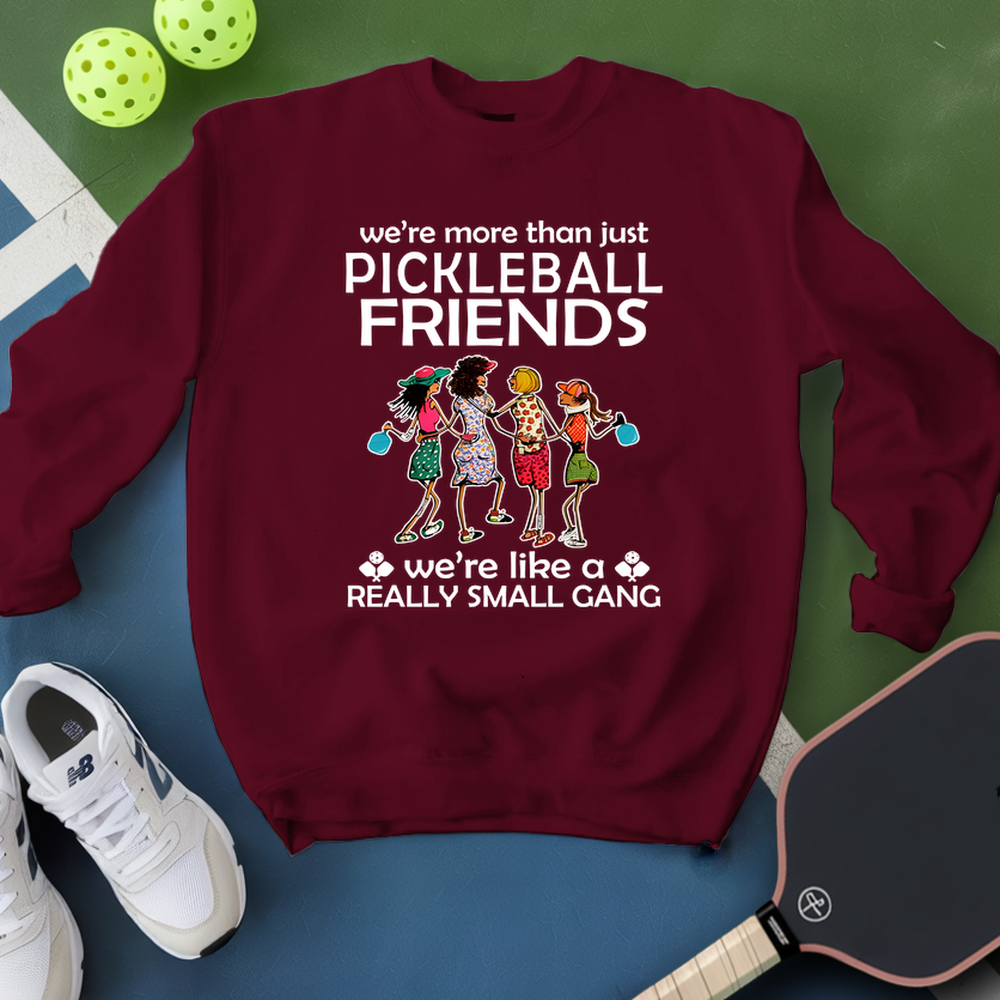 Maroon sweatshirt with pickleball-themed design on a blue and green background