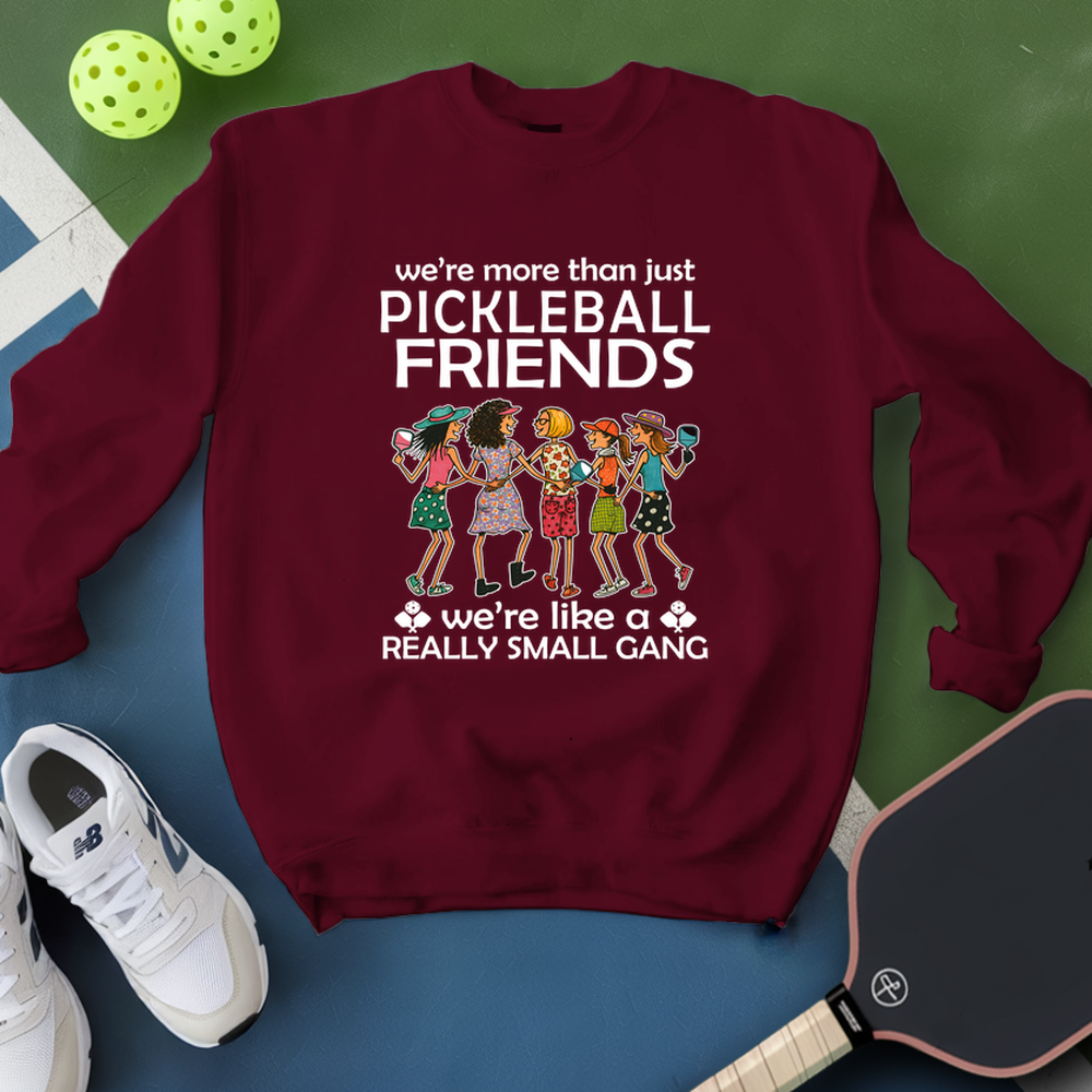 Maroon sweatshirt with pickleball-themed design on a green and blue background