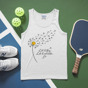 White tank top with dandelion design and text, placed on a green and blue surface with pickleballs and a paddle.